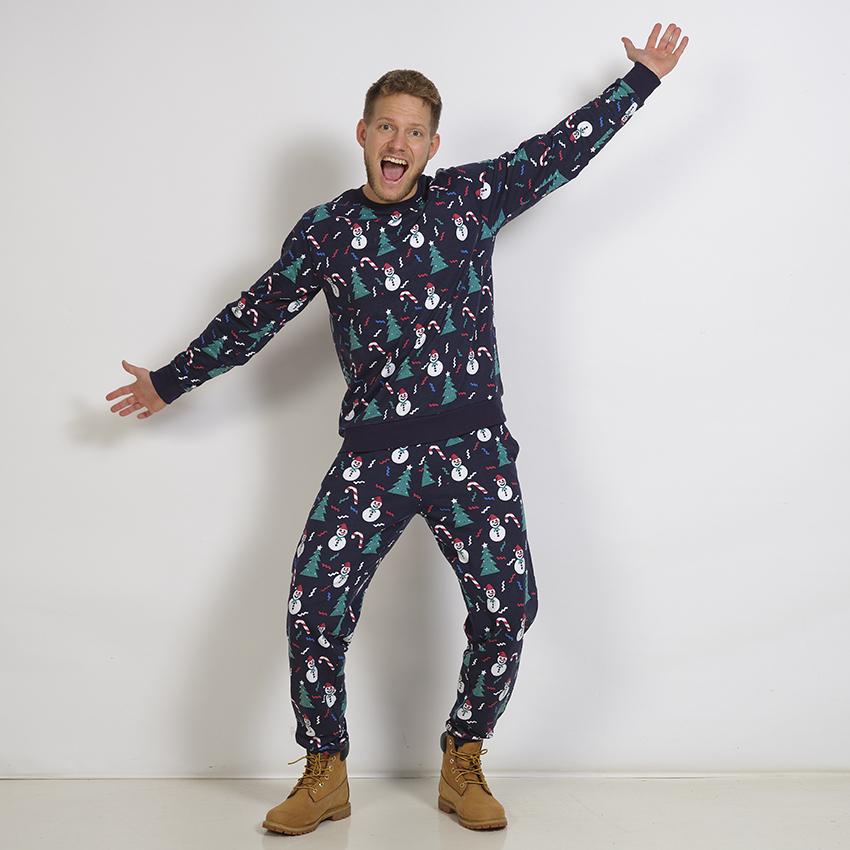 En poserande man i en blå jultröja.